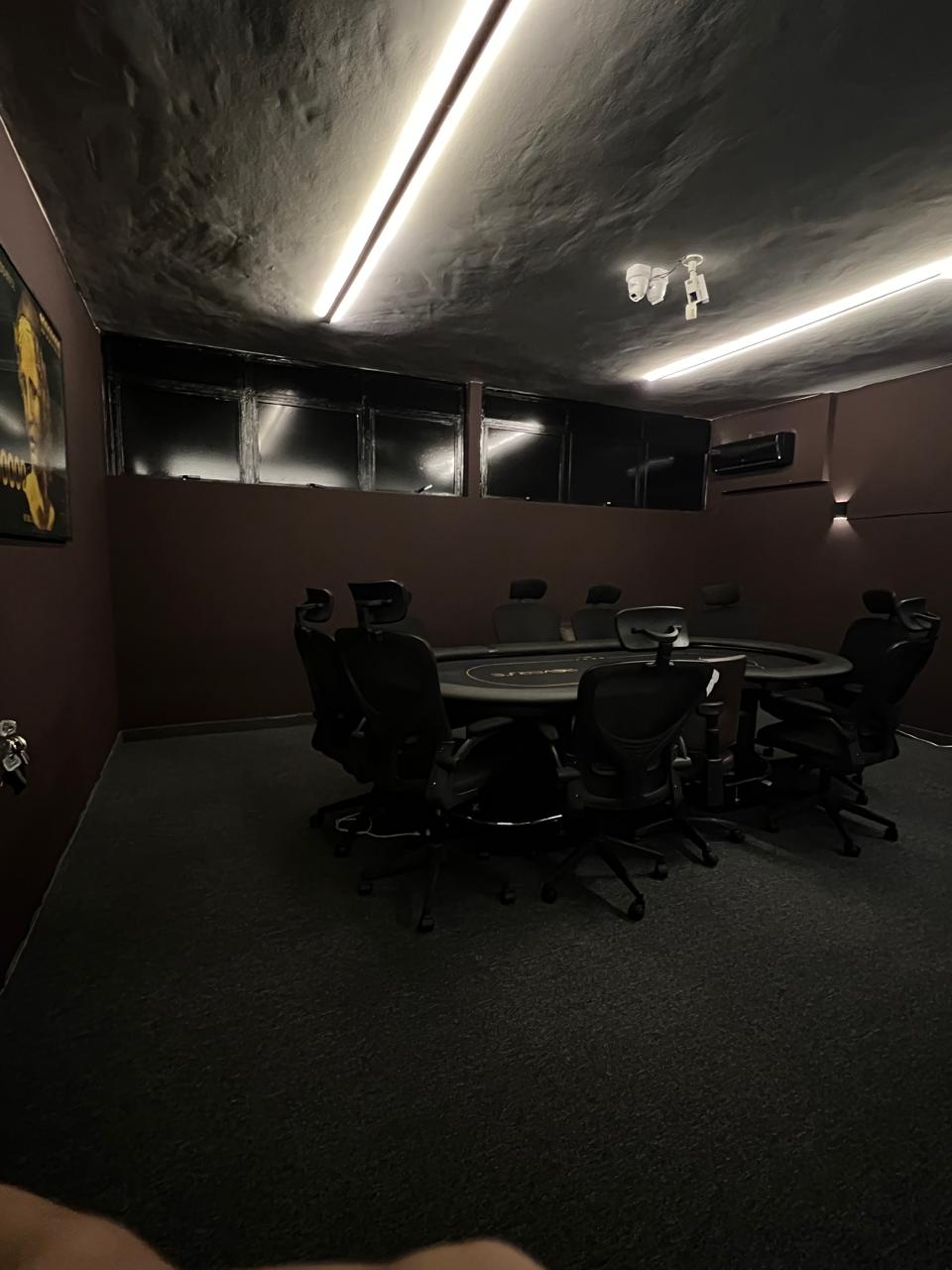 Sala VIP em luz baixa, com as linhas de LED do teto refletindo no pano da mesa