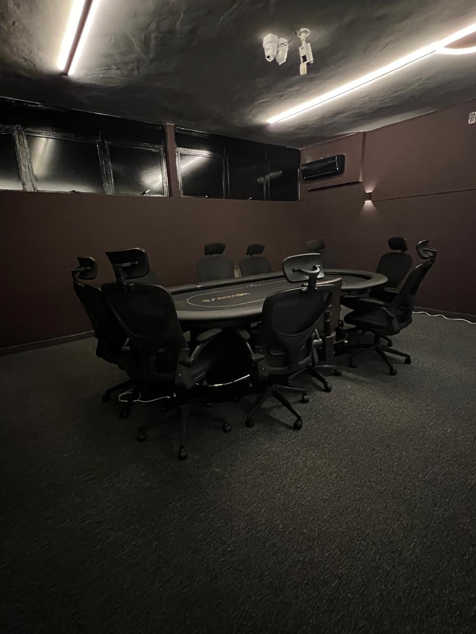 Vista ampla da sala VIP com poltronas ergonomicas em volta da mesa de poker